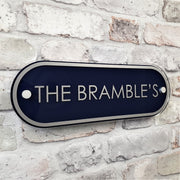 "Blue house name sign saying 'The Brambles'' on a wall"