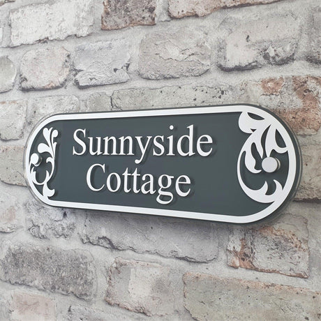 Slate grey address plaque saying 'Sunnyside Cottage' in white font